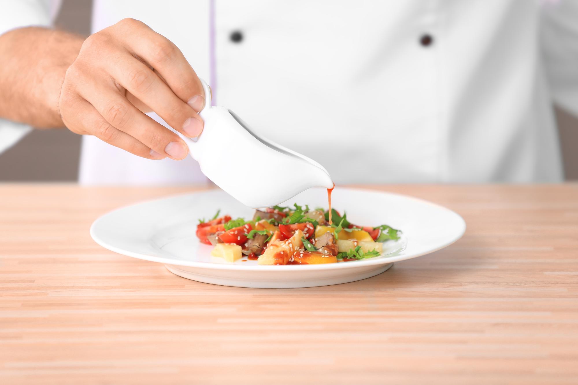 Chef preparing plated dish in bright kitchen